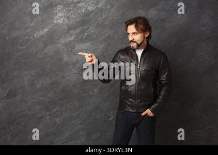 Mann in Lederjacke zeigt in Collage verschiedener Hintergründe und Szenen in der Creative Collection Stockfoto
