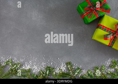 Bunte Sammlung von Geschenkboxen und grünen Ästen auf grauer Oberfläche Stockfoto