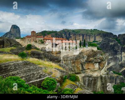 METERORA, GFEECE - 11. MAI 2025 - das Kloster Varlaam thront auf einem felsigen Gipfel inmitten der dramatischen Landschaft von Meteora, Griechenland, überragt von der Wolke Stockfoto