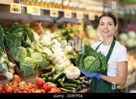 Weibliche Lebensmittelläden bieten Reifen Brokkoli-Kohl in der Lebensmittelabteilung des Supermarktes an Stockfoto