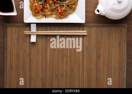 Collage einer Speiseszene mit festem Essen und Utensilien auf einer Bambusmatte Stockfoto