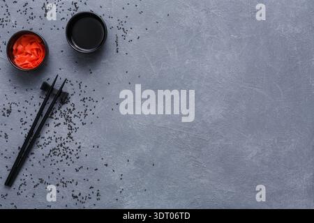 Sushi-Zubereitung mit eingelegtem Ingwer und Sojasauce auf grauer Oberfläche Stockfoto