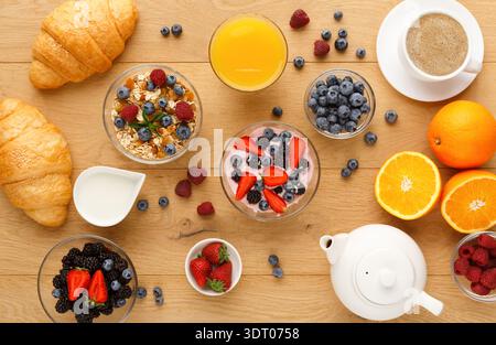 Zum Frühstück gab es Obst, Joghurt und Gebäck in einer Collage auf einem Holztisch Stockfoto