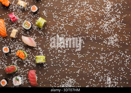 Sammlung von Sushi-Stücken auf einem Holztisch mit Streureis Stockfoto