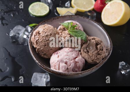 Verschiedene Geschmacksrichtungen von Eis serviert in einer Schüssel mit Obst und Eis Stockfoto