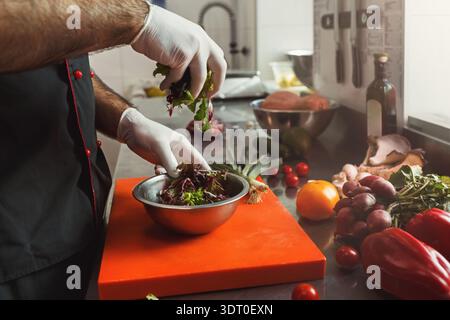 Zubereitung eines frischen Salats mit verschiedenen Gemüsesorten in der Küche tagsüber Stockfoto