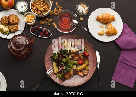 Sammlung von Gerichten, die auf einem Tisch während einer Mahlzeit in einem Speisesaal serviert werden Stockfoto