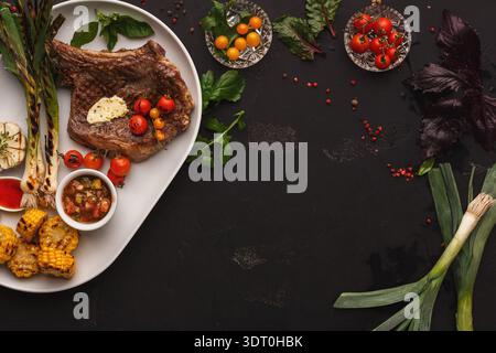 Sammlung von Lebensmitteln auf einer schwarzen Oberfläche mit verschiedenen Zutaten und Garnituren angeordnet Stockfoto