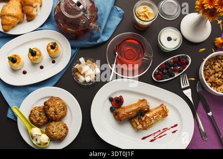 Auf Tellern servierte Gerichte mit Getränken und Desserts auf einem Tisch Stockfoto