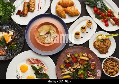 Diverse Essenskollektion auf einem Tisch mit verschiedenen Gerichten und Zutaten sorgfältig angeordnet Stockfoto