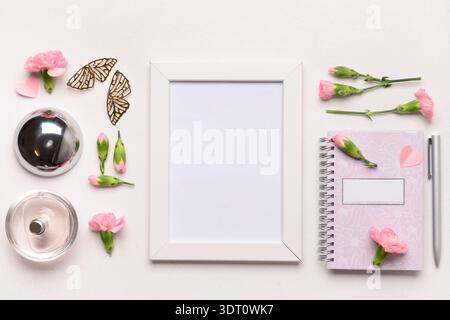 Fotorahmen mit Notizbuch und schönen Blumen auf weißem Hintergrund Stockfoto