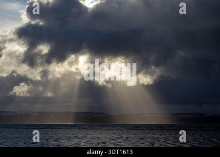 Sonnenstrahlen brechen durch Wolken über der Dee Mündung Stockfoto