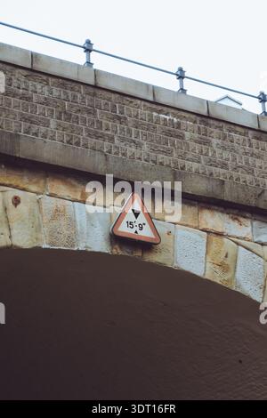 Ein Warnschild auf einer niedrigen Brücke, das die maximal zulässige Höhe für Fahrzeuge anzeigt Stockfoto