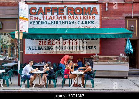 Die Menschen sitzen vor dem Caffe Roma in Little Italy und genießen an einem sonnigen Tag italienische Backwaren und Getränke. Das Café hat eine einladende Atmosphäre. Stockfoto