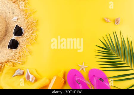 Urlaubsplanung einfaches Thema der Strohhut Sonnenbrille Flipflops und Palmblätter auf einheitlichem gelbem Hintergrund flach mit Kopierraum Stockfoto