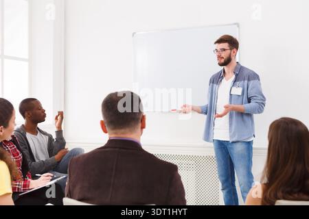Gruppe von Personen, die tagsüber an einer Präsentation in einem Klassenzimmer teilnehmen Stockfoto