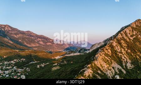 Aus der Vogelperspektive auf die zerklüfteten, sonnenverwöhnten Berge und üppigen Täler, die einen atemberaubenden Kontrast aus Licht und Schatten schaffen, Čanj, Montenegro. Stockfoto