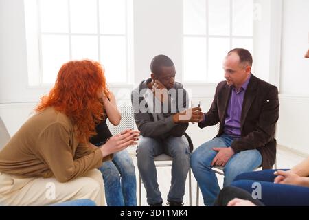 Gruppendiskussion in einem Besprechungsraum mit vier Personen, die sich unterhalten und Ideen und Getränke austauschen Stockfoto