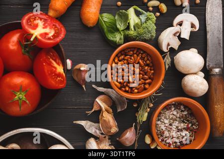 Sammlung von frischem Gemüse und Zutaten zum Kochen auf einem schwarzen Tisch Stockfoto