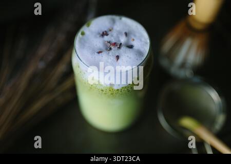 Ein verführerischer Matcha Latte mit cremigem Schaum, elegant in einem Glas präsentiert. Die sanfte Mischung aus grünem Tee und Milch sorgt für eine erfrischende vibra Stockfoto