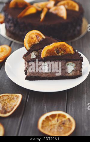 Dessertsammlung mit Schokoladenkuchen und getrockneten Orangenscheiben auf einem Holztisch Stockfoto