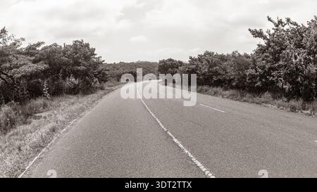 Road Hill durch die Landschaft auf der Route Asphalt Sommer Sepia schwarz weiß abstrakte Landschaft Stockfoto
