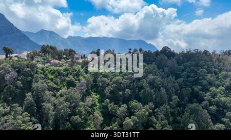 Sonnendurchflutetes Dorf Cemoro Lawang, bunte Dächer verstreut zwischen grünen Terrassen hoch über der Bromo Caldera. Stockfoto
