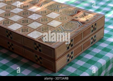 Geschlossenes libanesisches Backgammon-Brett, Tawle, auf eine grüne karierte Tischdecke gestellt. Stockfoto