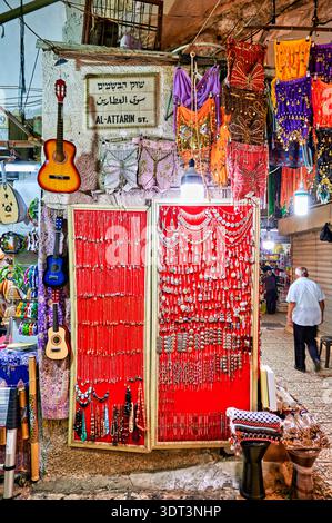 Besucher stöbern in einem Geschäft im Souq al attarin, wo sie bunten Schmuck und Kunsthandwerk bewundern. Die Szene zeigt das Leben auf dem geschäftigen Markt in Jerusalem. Stockfoto