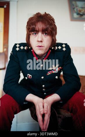 Ein junger Mann in modischer Mode gekleidet, trug eine Vintage Army Uniform Jacke mit verschiedenen militärischen Insignien und Medaillenband, England, 2003 Stockfoto