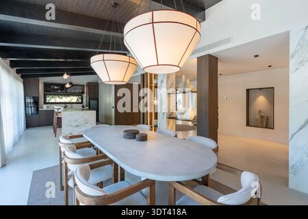 ein Bild eines luxuriösen Steintisches neben einer offenen Küche in einer mediterranen Immobilienimmobilie Stockfoto