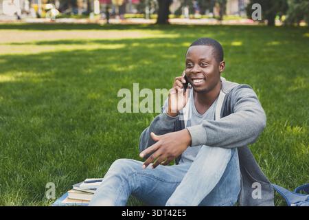 Unterhaltung im Park mit Büchern und einem Telefon an einem sonnigen Tag Stockfoto