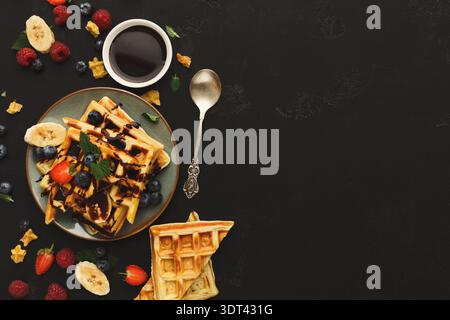 Delicious Waffle Collection mit Früchten und Sirup auf dunklem Hintergrund Stockfoto