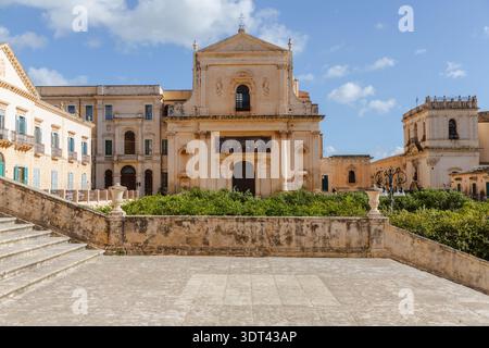 Der Blick auf die großartige barocke Architektur der Kathedrale von Noto erhebt sich majestätisch über den Steintreppen auf dem Platz, deren Fassade unter dem weichen Licht leuchtet Stockfoto
