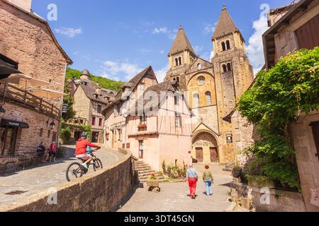 Conques, Frankreich - 10. Juni 2024: Das malerische und charmante Stadtzentrum und die Abteikirche Sainte-Foy des mittelalterlichen französischen Dorfes Conques in Aveyron, Stockfoto