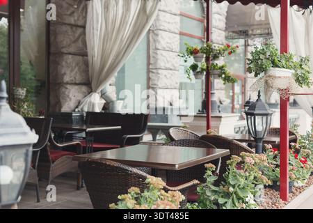 Sammlung von Outdoor Cafe Tischen und Dekor in gemütlicher urbaner Umgebung tagsüber Stockfoto