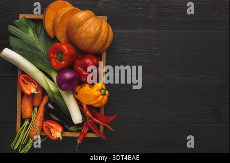 Sammlung von bunten Gemüse und Früchten in einer Holzkiste auf dunkler Oberfläche Stockfoto