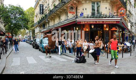 PARIS, FRANKREICH - 4. OKTOBER 2014: Ein nicht identifizierter junger Mann macht Backflip, während er Capoeira vor dem Publikum im Quartier Latin aufführt. Dutzende Künstler pe Stockfoto