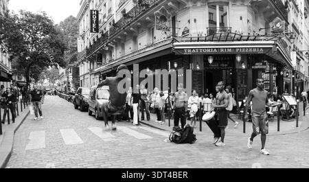 PARIS, FRANKREICH - 4. OKTOBER 2014: Ein nicht identifizierter junger Mann macht Backflip, während er Capoeira vor dem Publikum im Quartier Latin aufführt. Schwarzweißfoto Stockfoto