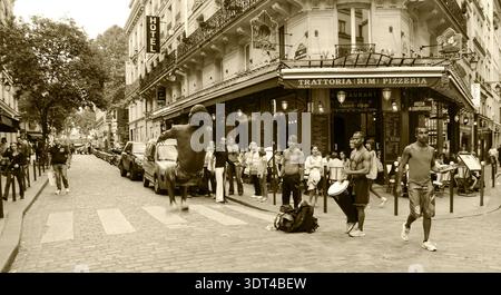 PARIS, FRANKREICH - 4. OKTOBER 2014: Junger Mann beim Backflip, während er Capoeira vor dem Publikum im Quartier Latin aufführt. Historisches Foto von Sepia. Stockfoto