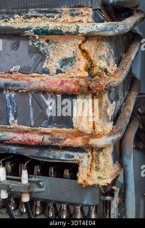 Detaillierte Ansicht von Mineralablagerungen und Rost an internen Teilen eines defekten Gas-Warmwasserbereiters, die darauf hinweist, dass Reparatur- oder Austauscharbeiten erforderlich sind Stockfoto