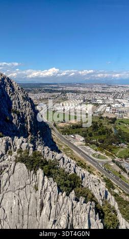 Erhöhte Aussicht von Tunektepe über schroffe Kalksteinklippen, Straßen, Industrieanlagen und die städtischen Randgebiete von Antalya, Türkei, am 7. April 2023. Stockfoto