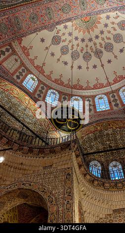 Verzierter Dom und Bögen im Neuen Moschee in Istanbul, Türkei, mit floralen osmanischen Mustern, arabischer Kalligraphie, Medaillon und gebogenen Fenstern Stockfoto