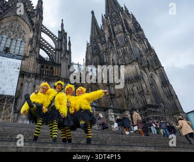 Während des Karnevals posieren Karnevalsfreunde in knallgelben Kostümen auf den Stufen des Kölner Doms Stockfoto