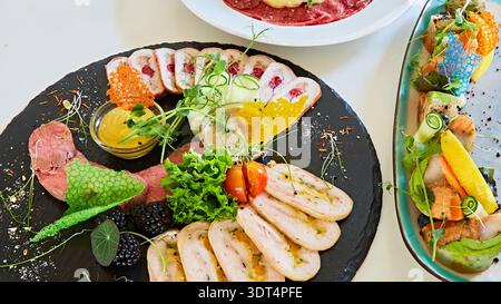 Luxuriöses Wurstschiefer mit handgefertigten Geflügelrouladen und gebratenem Fleisch mit lebhaften Tuiles, einer multisensorischen Darstellung von reichhaltigen Texturen und üppigen C Stockfoto