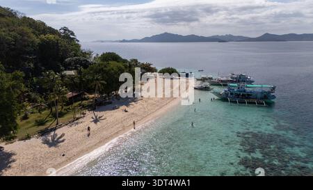 Drone aus der Vogelperspektive auf Banana Island, einem tropischen Strand mit türkisfarbenem Wasser, weißem Sand und einem bangka-Boot in Coron, Palawan, Philippinen. Hohe Qualität Stockfoto