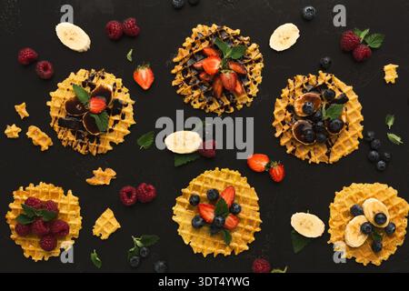Verschiedene Arten von Waffeldesserts auf kreative Weise auf dunkler Oberfläche angeordnet Stockfoto