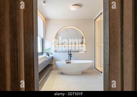 ein Bild eines luxuriösen beleuchteten Badezimmers mit freistehender Badewanne in einem mediterranen Ferienhaus Stockfoto