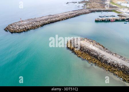 Hohe Drohnenansicht der zwei Wellenbrecher, die den Eingang zu einem Seehafen bilden Stockfoto
