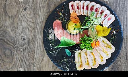 Luxuriöses Wurstschiefer mit handgefertigten Geflügelrouladen und gebratenem Fleisch mit lebhaften Tuiles, einer multisensorischen Darstellung von reichhaltigen Texturen und üppigen C Stockfoto